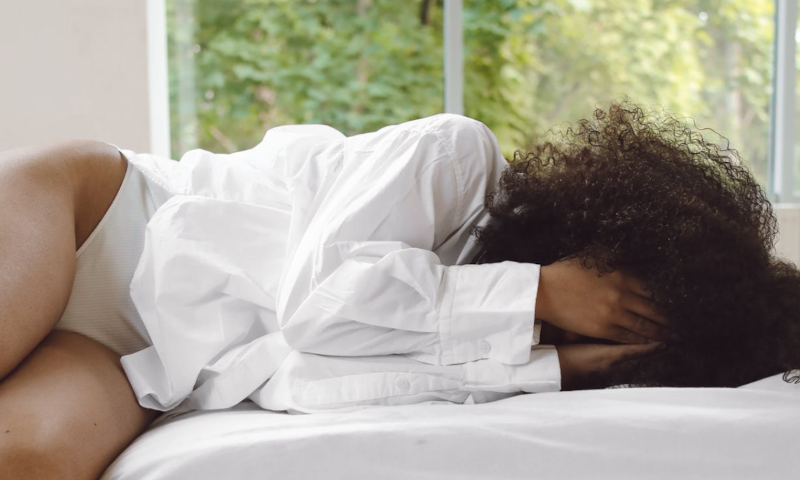 Met hoofdpijn op bed liggen